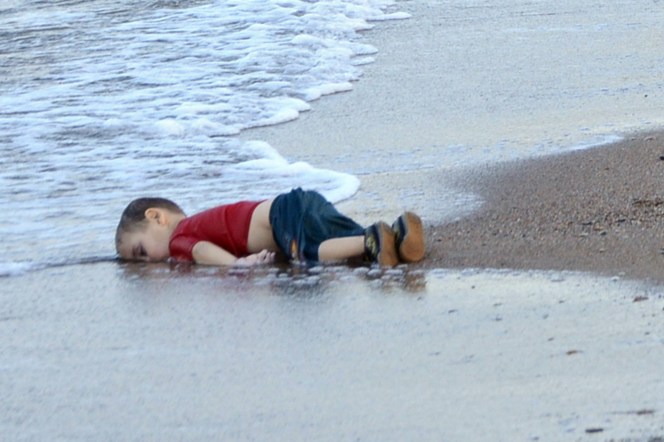 epa04910104 Washed up body of a refugee child who drowned during a failed attempt to sail to the Greek island of Kos, at the shore in the coastal town of Bodrum, Mugla city, Turkey, 02 September 2015. At least 11 Syrian migrants died in boat sank after leaving Turkey for the Greek island of Kos. EPA/DOGAN NEWS AGENCY ATTENTION EDITORSgraphic content ATTENTION EDITORS: PICTURE CONTAINS GRAPHIC CONTENT ; TURKEY OUT