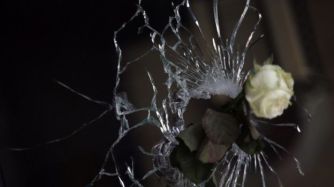 A rose in a bullet hole in the window of a restaurant in the city. Getty Images